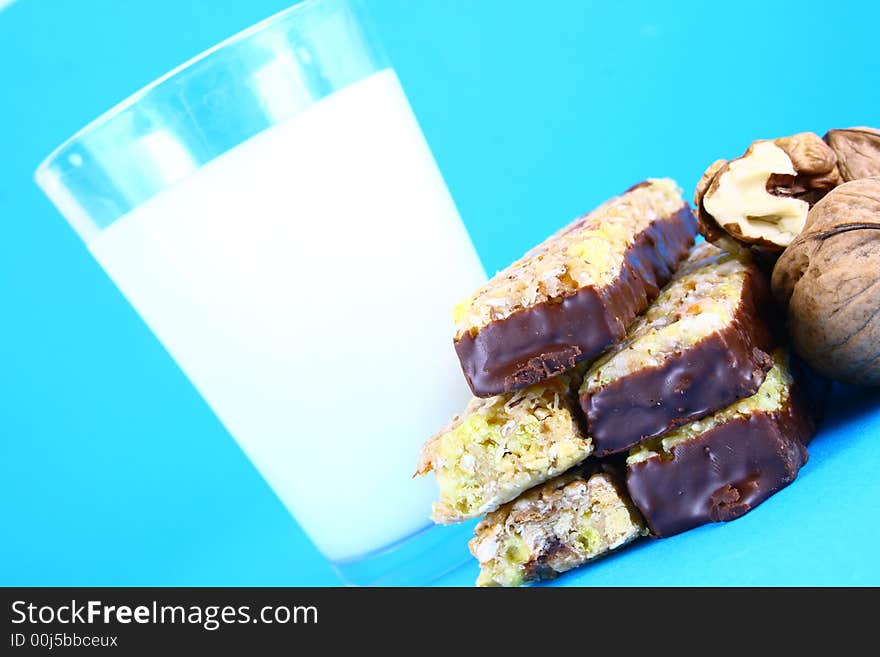 Pouring white milk against blue background and glass. Pouring white milk against blue background and glass