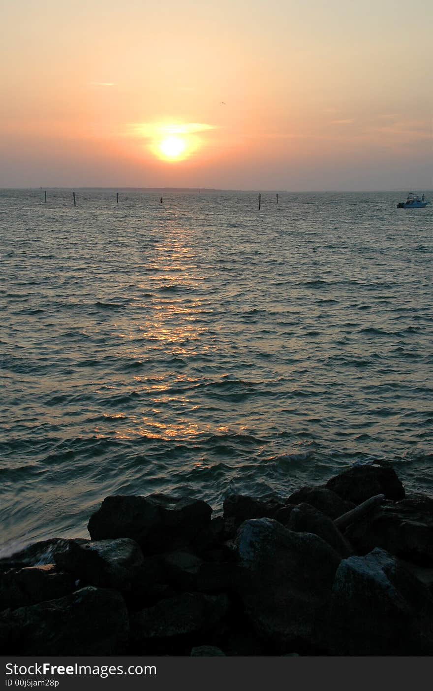 Sunset at a rocky beach with reflections on the water. Sunset at a rocky beach with reflections on the water