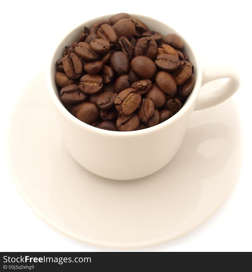 Cup of coffee beans on saucer. isolated on white background