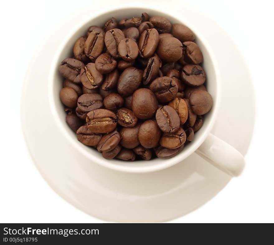 Cup of coffee beans on saucer. isolated on white background