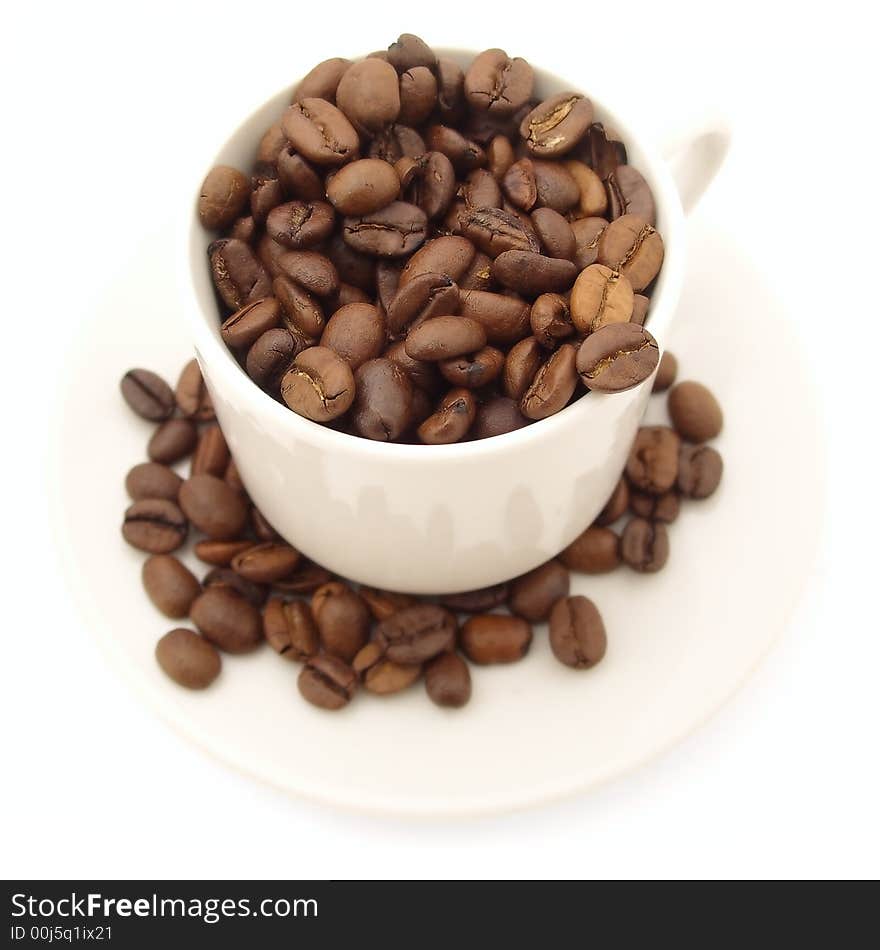 Cup of coffee beans on saucer. isolated on white background