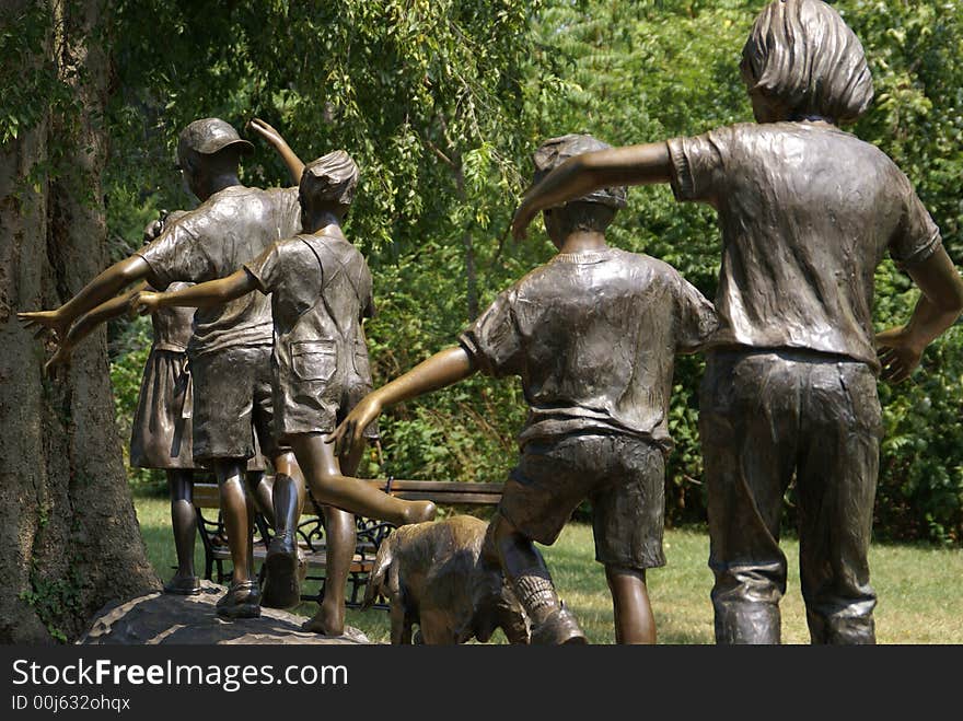 Statue of children and dog playing on a log. Statue of children and dog playing on a log