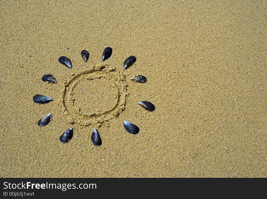 Drawing of the sun in the sand made with shells