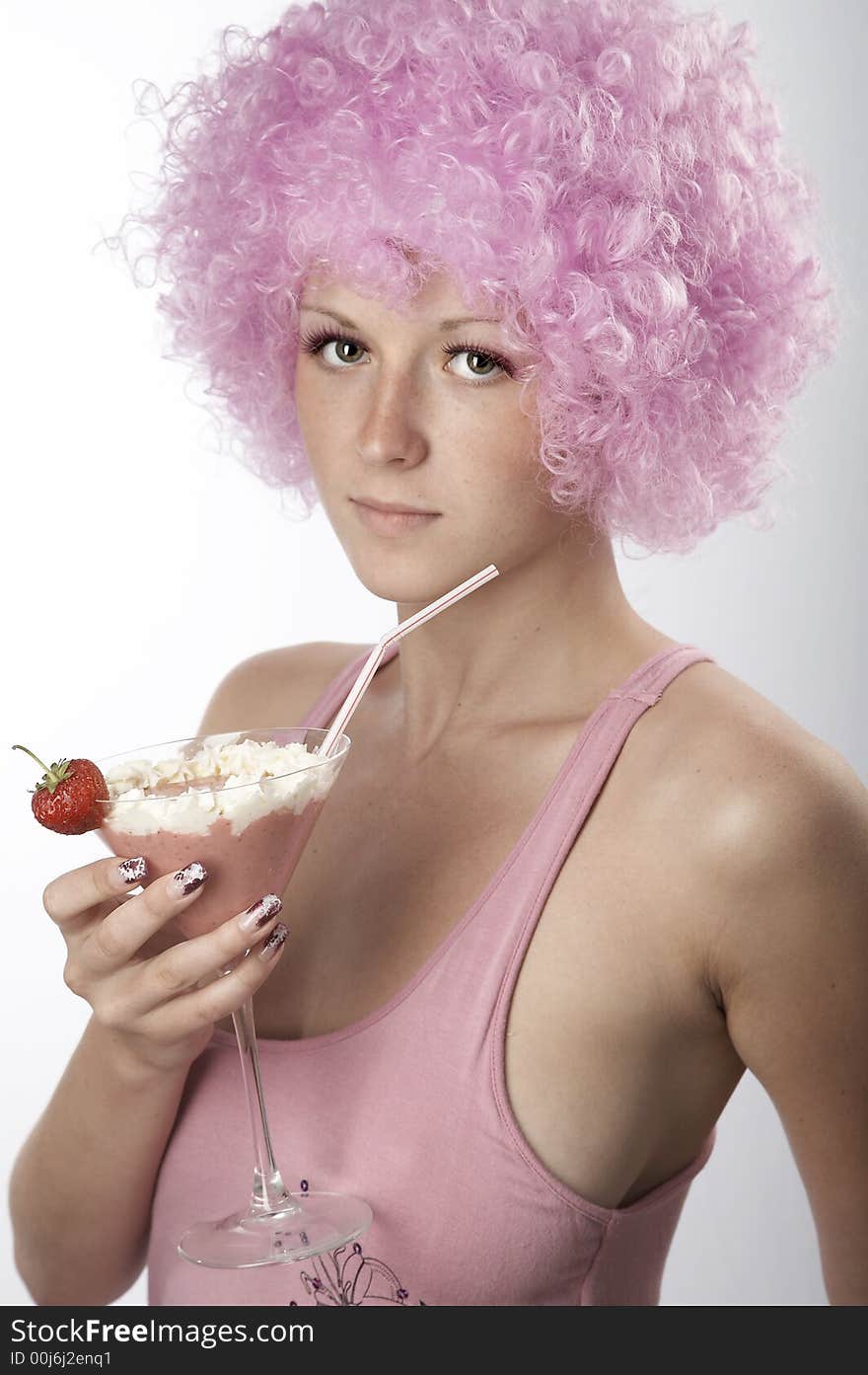 Pretty girl in pink dress and wig with strawberry cocktail