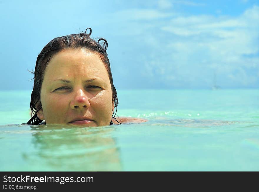 Mid age woman swimming in crystal clear turquoise ocean, Seychelles. Mid age woman swimming in crystal clear turquoise ocean, Seychelles