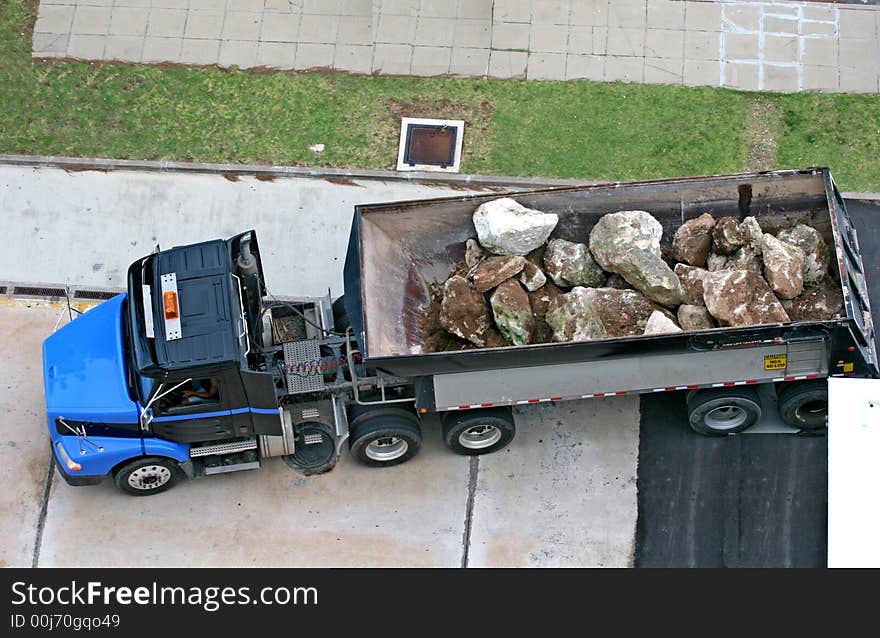 A large dump truck filled with massive boulders. A large dump truck filled with massive boulders