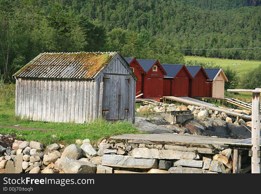 Old weathered and some new boathouses by a sea