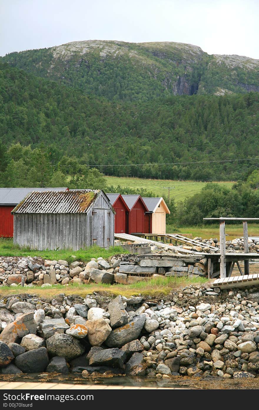 Old weathered and some new boathouses by a sea