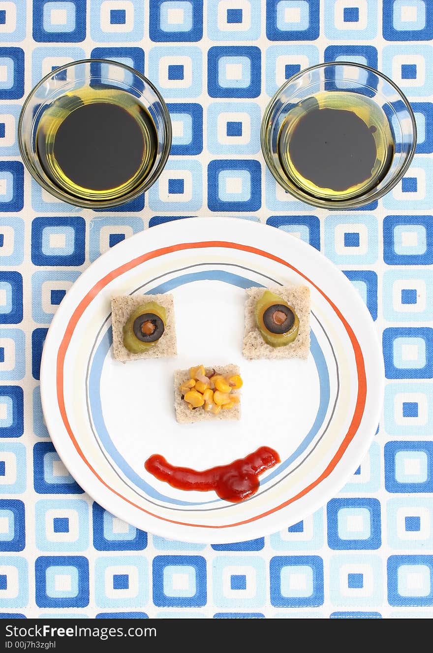 Fruit and vegetable canapes arranged as a face on a small plate. Fruit and vegetable canapes arranged as a face on a small plate