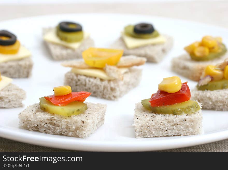 Fruit and vegetable canapes on a white ceramic plate. Fruit and vegetable canapes on a white ceramic plate