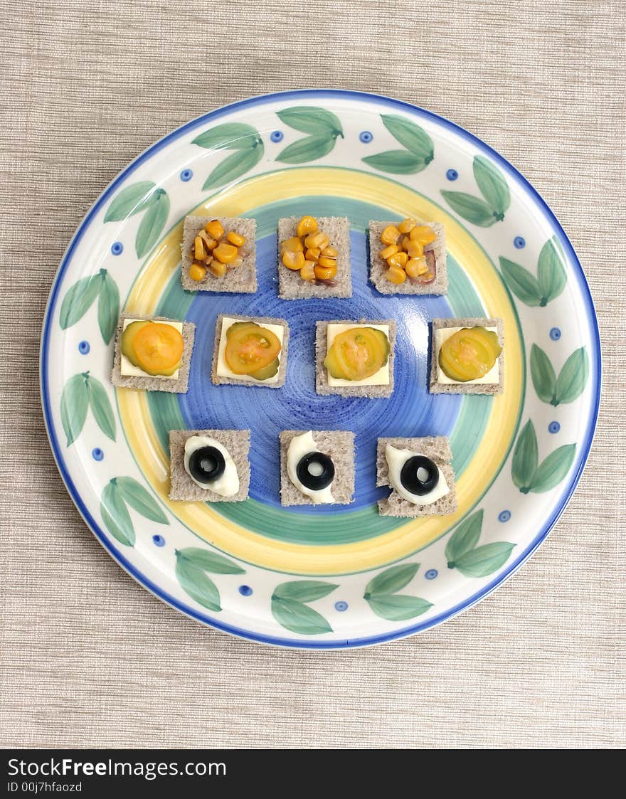 Fruit and vegetable canapes arranged as a face on a small plate. Fruit and vegetable canapes arranged as a face on a small plate