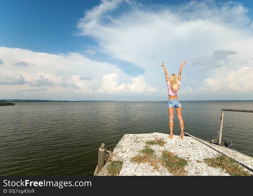 The young beautiful woman stands on seacoast. The young beautiful woman stands on seacoast