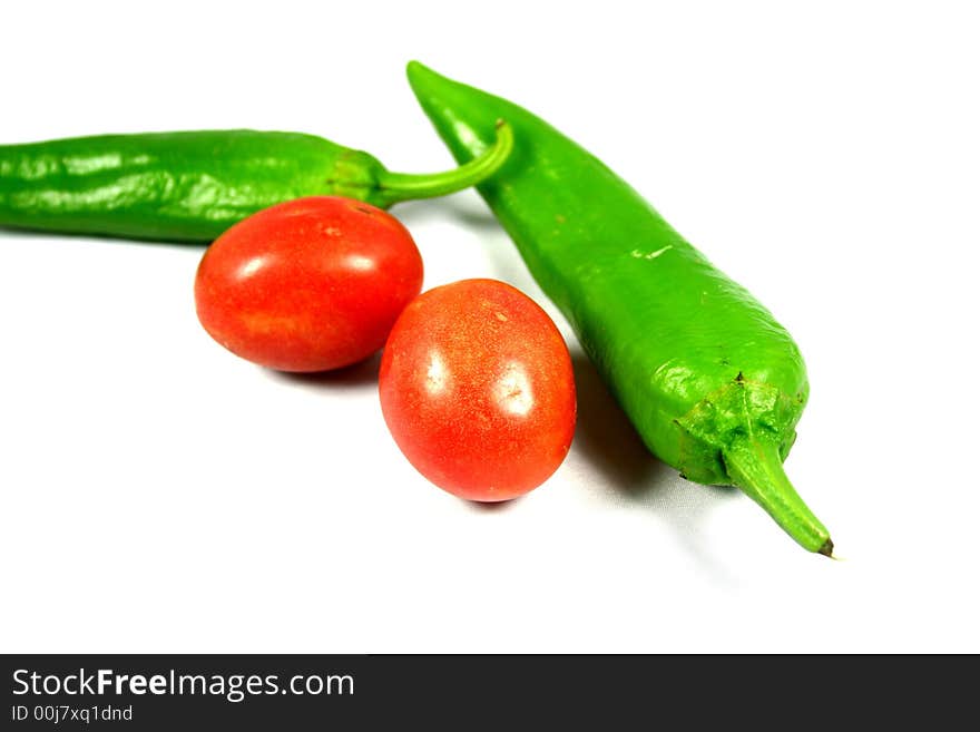 Two macro tomatoes with green hot peppers  bright red and juicy looking. Two macro tomatoes with green hot peppers  bright red and juicy looking