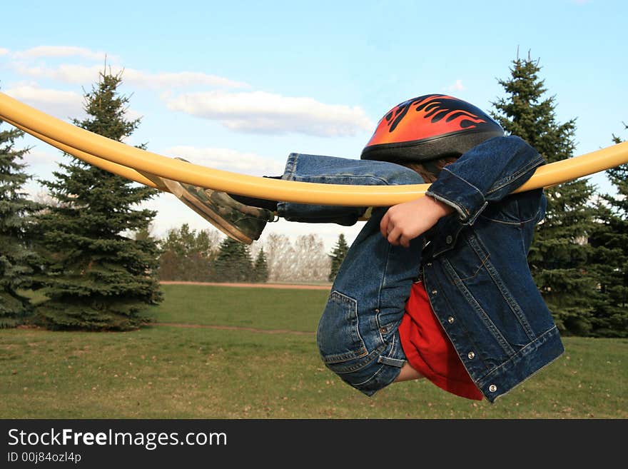 Young boy hanging on playground equipment. Young boy hanging on playground equipment.