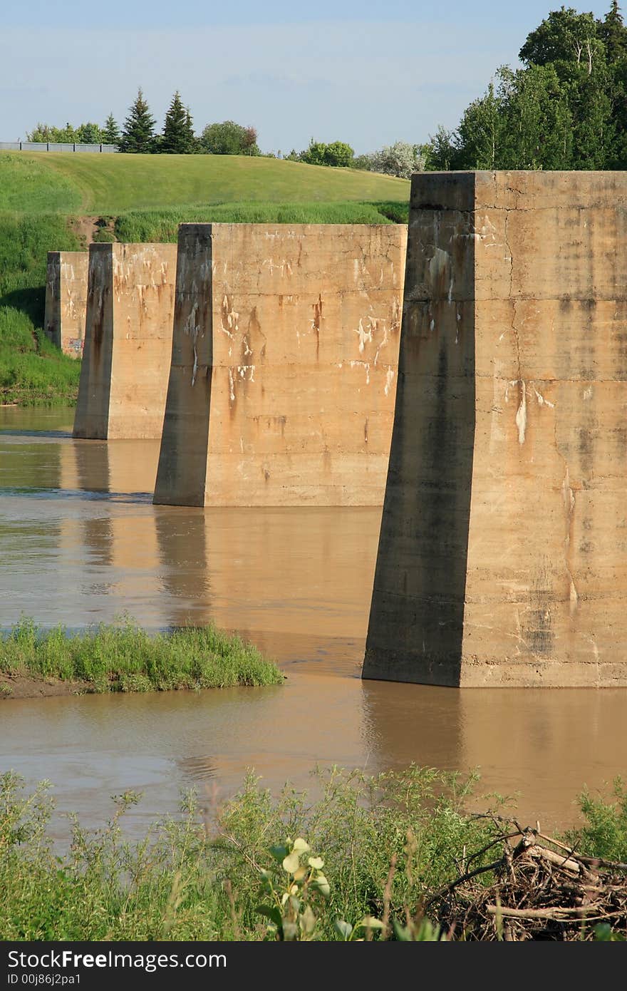 Abandoned railway bridge pilings lined up across a river. Abandoned railway bridge pilings lined up across a river.