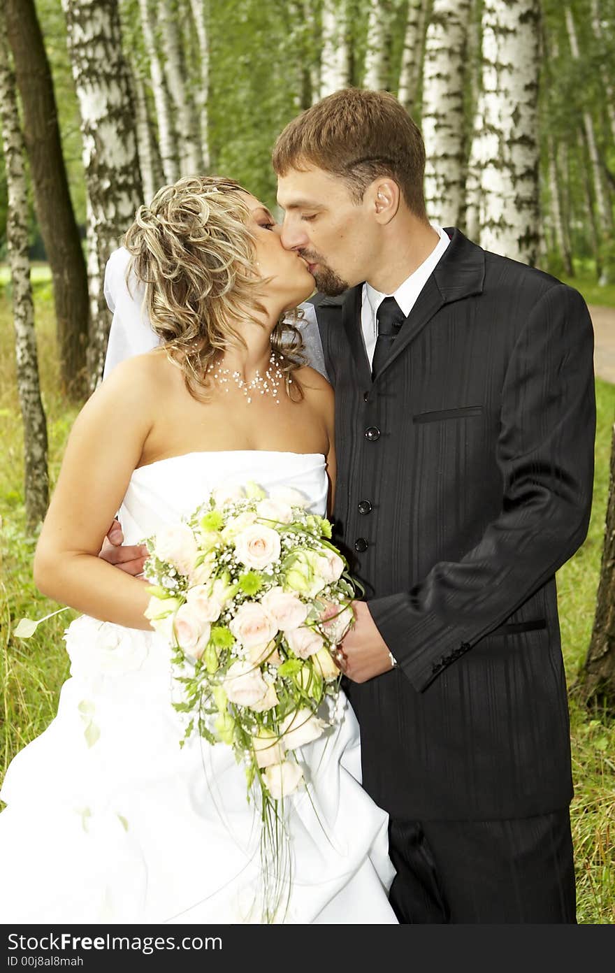 A couple on their wedding day kissing