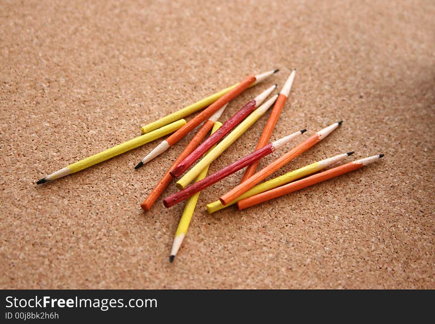 Miniature pencils on a cork background. Miniature pencils on a cork background