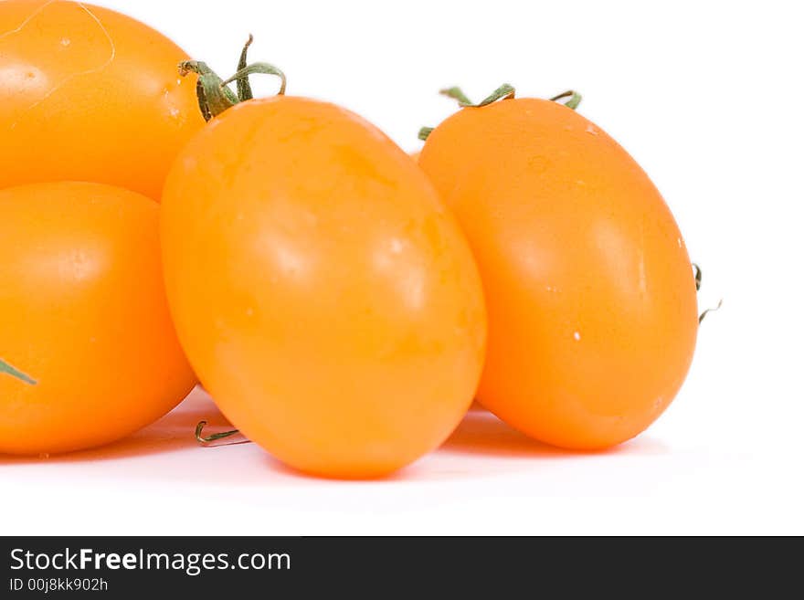 Fresh yellow tomatoes over white