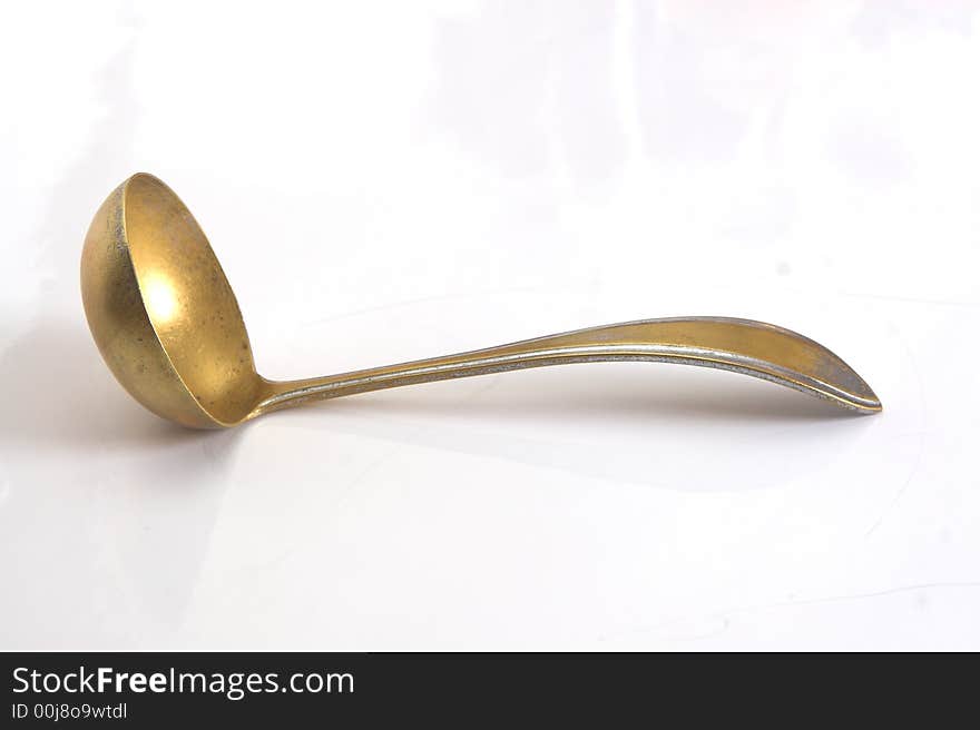 Ancient brass soup spoon isolated on white