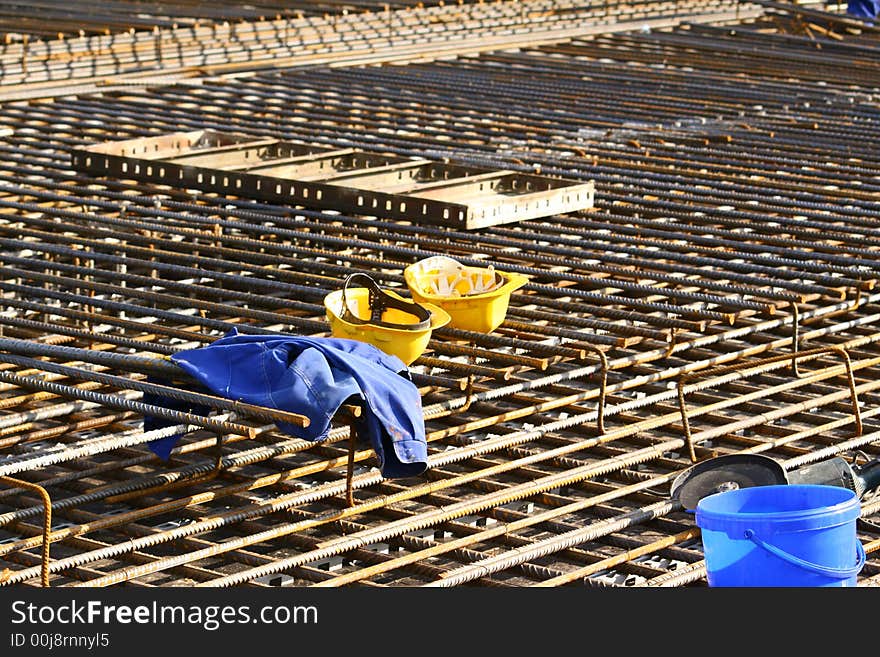 Yellow helmets lying on a heavy reinforcement with lots of steel-bar. Yellow helmets lying on a heavy reinforcement with lots of steel-bar