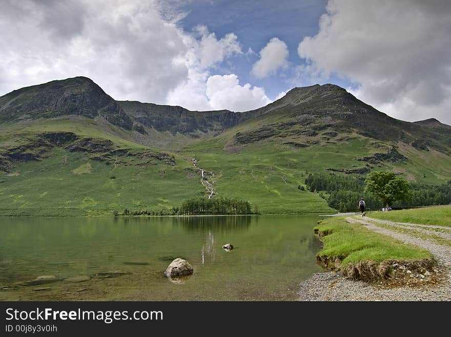 A female hiker on the shore of Buttermere in the English Lake District. A female hiker on the shore of Buttermere in the English Lake District