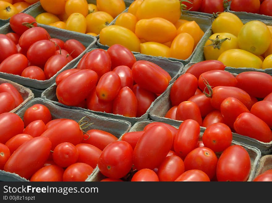 A display of red and yellow plum tomatoes at an outdoor market in Ottawa, Canada. A display of red and yellow plum tomatoes at an outdoor market in Ottawa, Canada