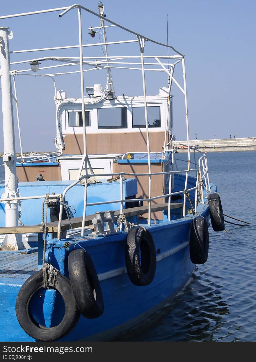 Floating boat anchored in harbor in a cloudless day