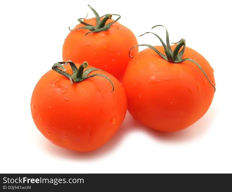 Three sweet tomatos. isolated on white. focus on first only.