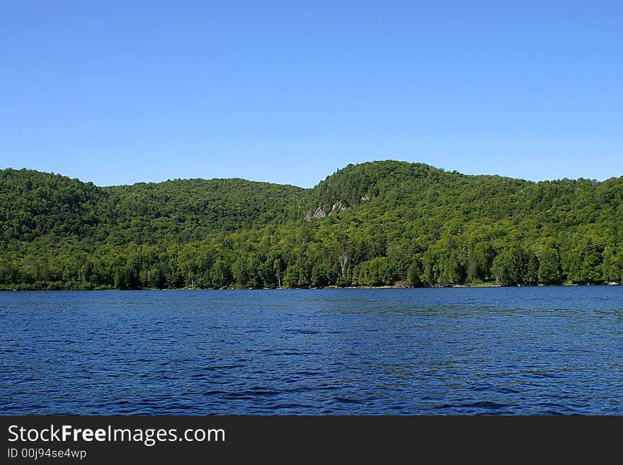 Green hills with blue sky form the lake