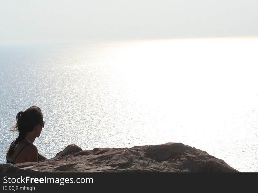 Girl between land and sea / Lighthouse Santorini Greece. Girl between land and sea / Lighthouse Santorini Greece