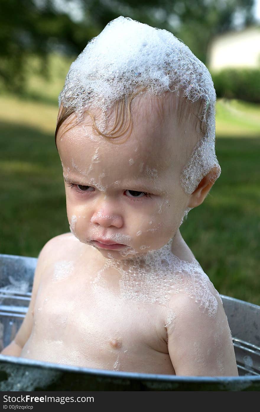 Image of cute toddler sitting in a tub outside. Image of cute toddler sitting in a tub outside