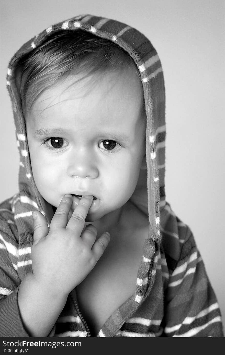 Black and white image of cute toddler wearing a hooded jacket