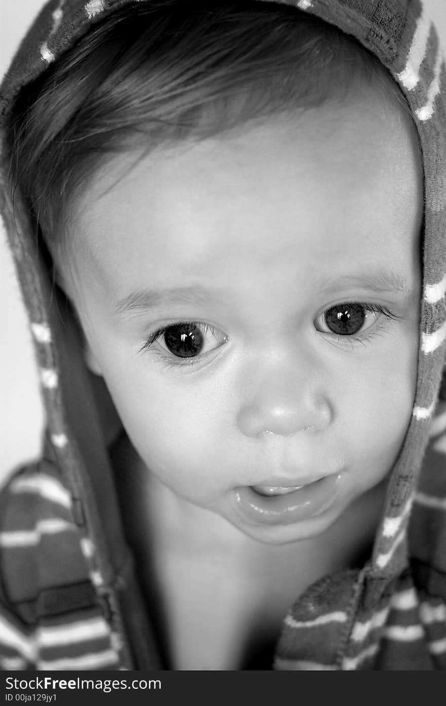 Black and white image of cute toddler wearing a hooded jacket