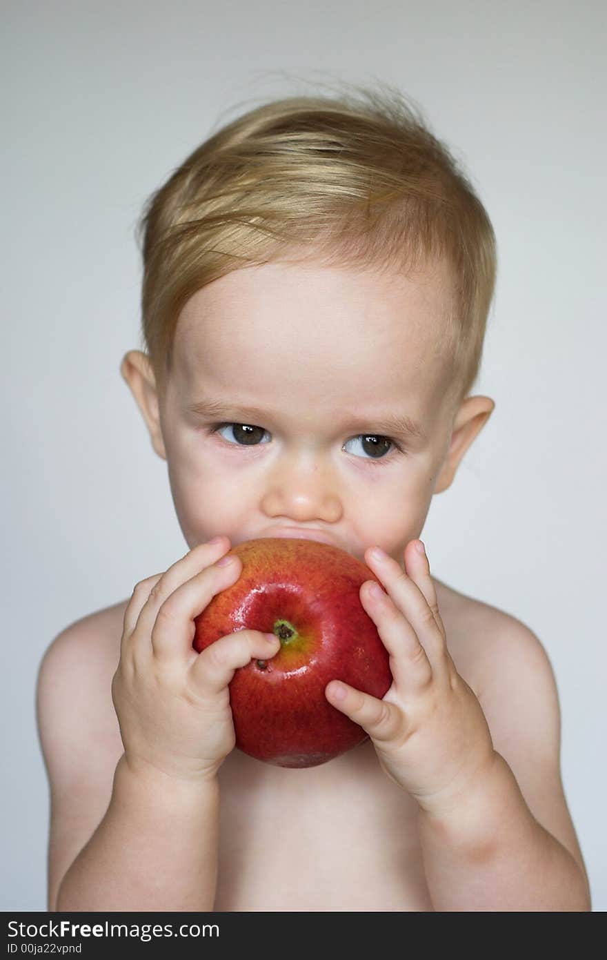 Image of cute toddler eating an apple. Image of cute toddler eating an apple