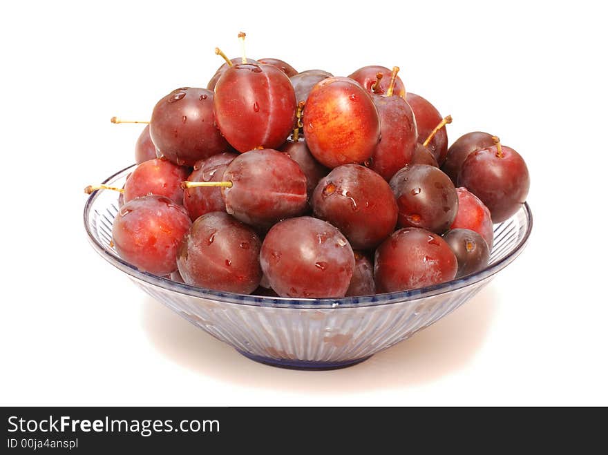 Glass bowl with plums isolated on white. Glass bowl with plums isolated on white