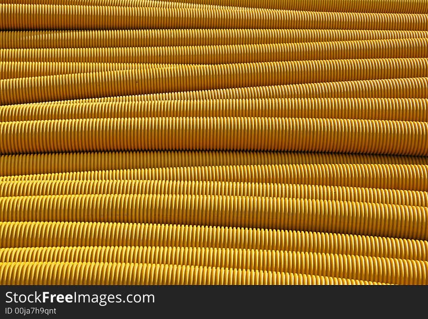 Ribbed orange pipes catch the earlymorning sunlight. Ribbed orange pipes catch the earlymorning sunlight.