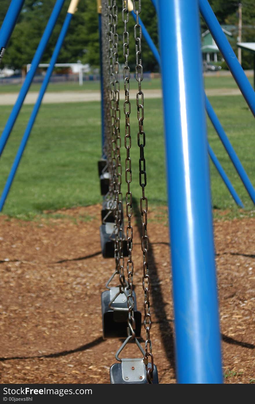 A blue swing set on a playground in the park