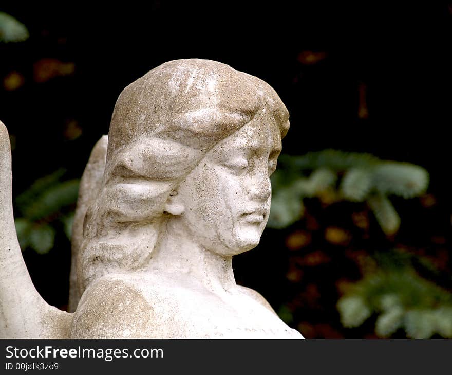 She sits in front of a very old cemetery. She sits in front of a very old cemetery.