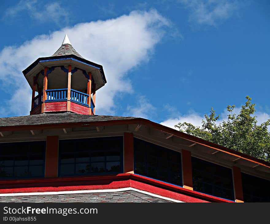 Colorful steeple on a building at an old amusement park against a blue sky. Colorful steeple on a building at an old amusement park against a blue sky