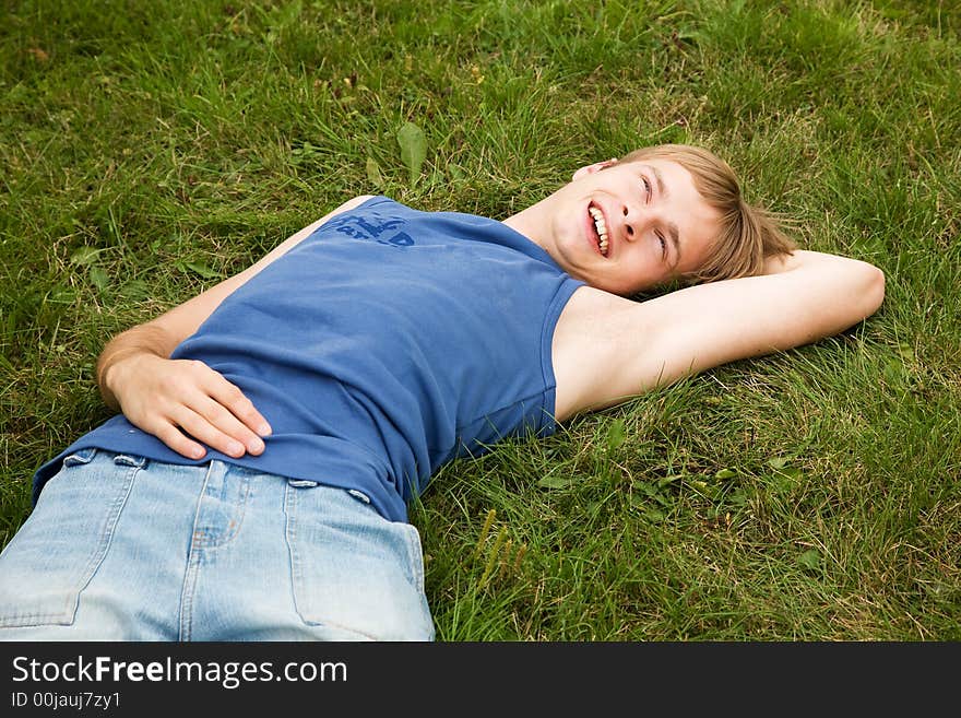 Smiling boy lying on the green grass