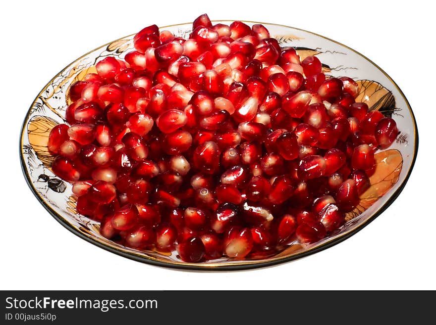 Pomegranate grains on a plate.  Isolated on white.