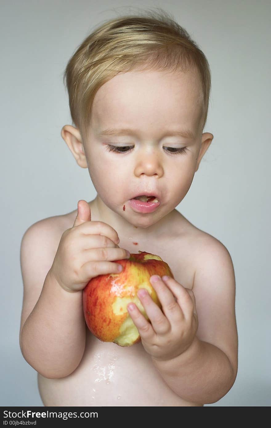 Image of cute toddler eating an apple. Image of cute toddler eating an apple