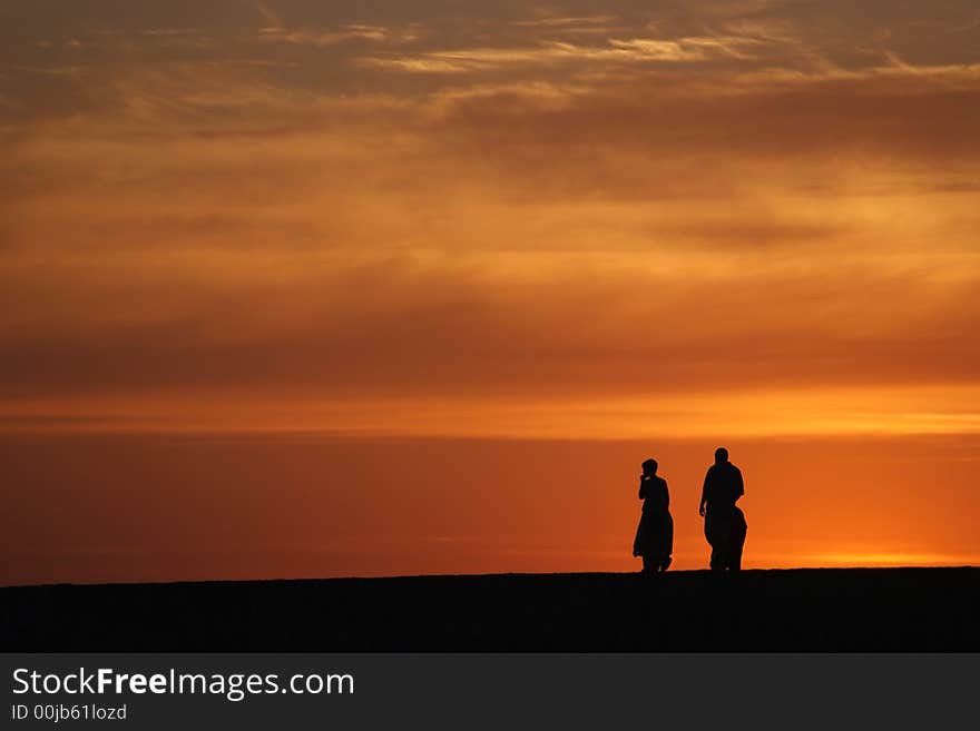 3 figures on a wall at sunset - Natural colors. 3 figures on a wall at sunset - Natural colors