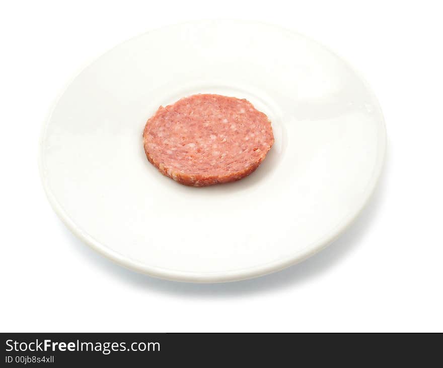 One sliece of smoked sausage on a plate. isolated on white.