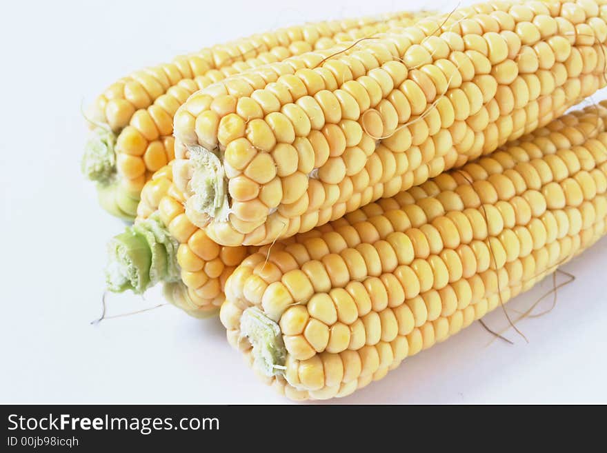 Four yellow cob corn on white background