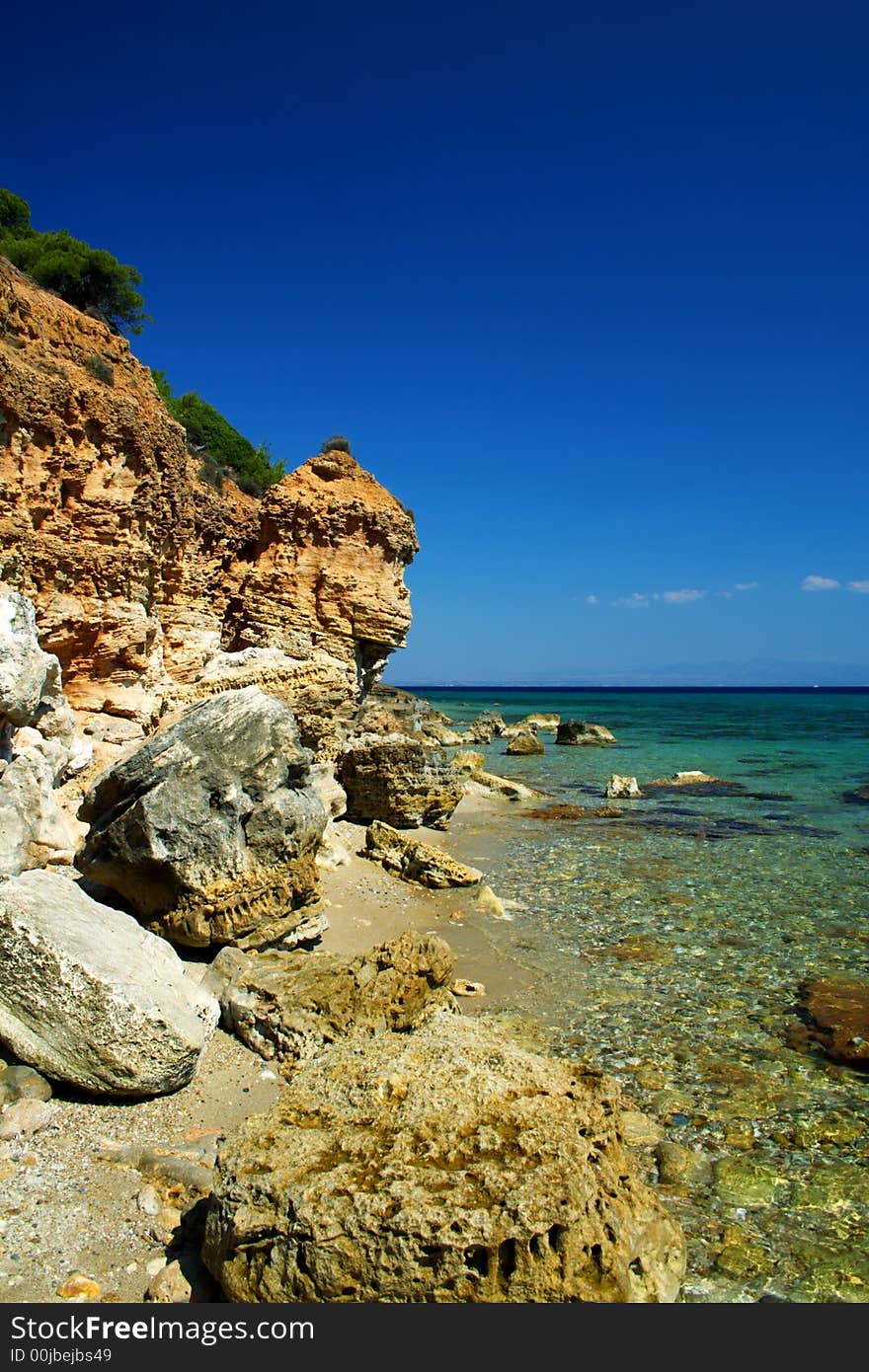 Sandy coast with rocks and blue sky