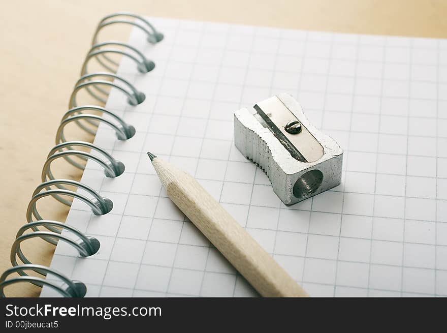 Pencil and sharpener over a white checkered binder