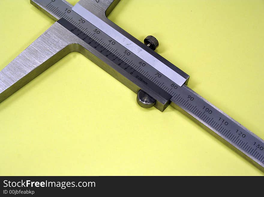 Caliper isolated against yellow background metal