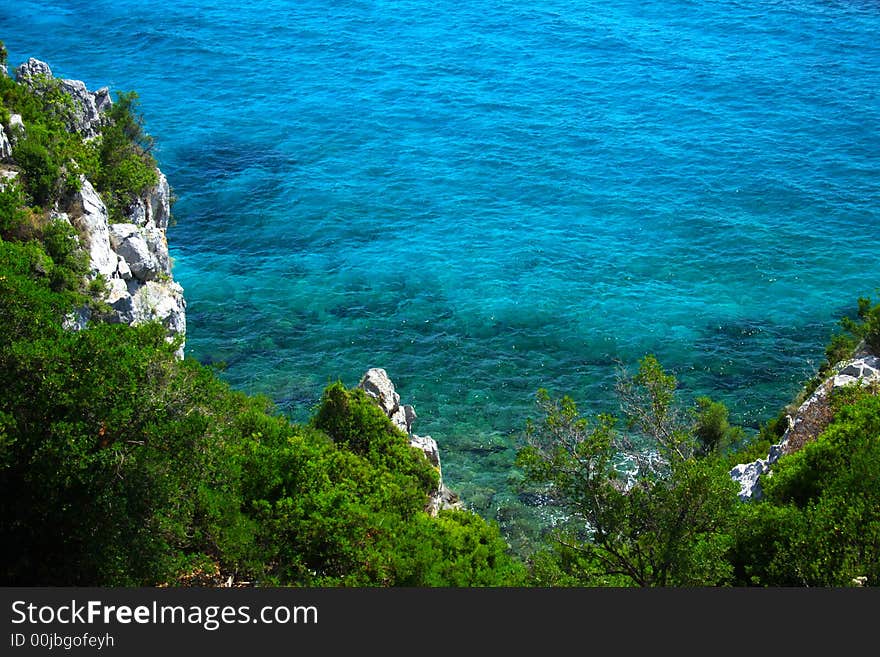 Coast with rocks, trees and blue sea