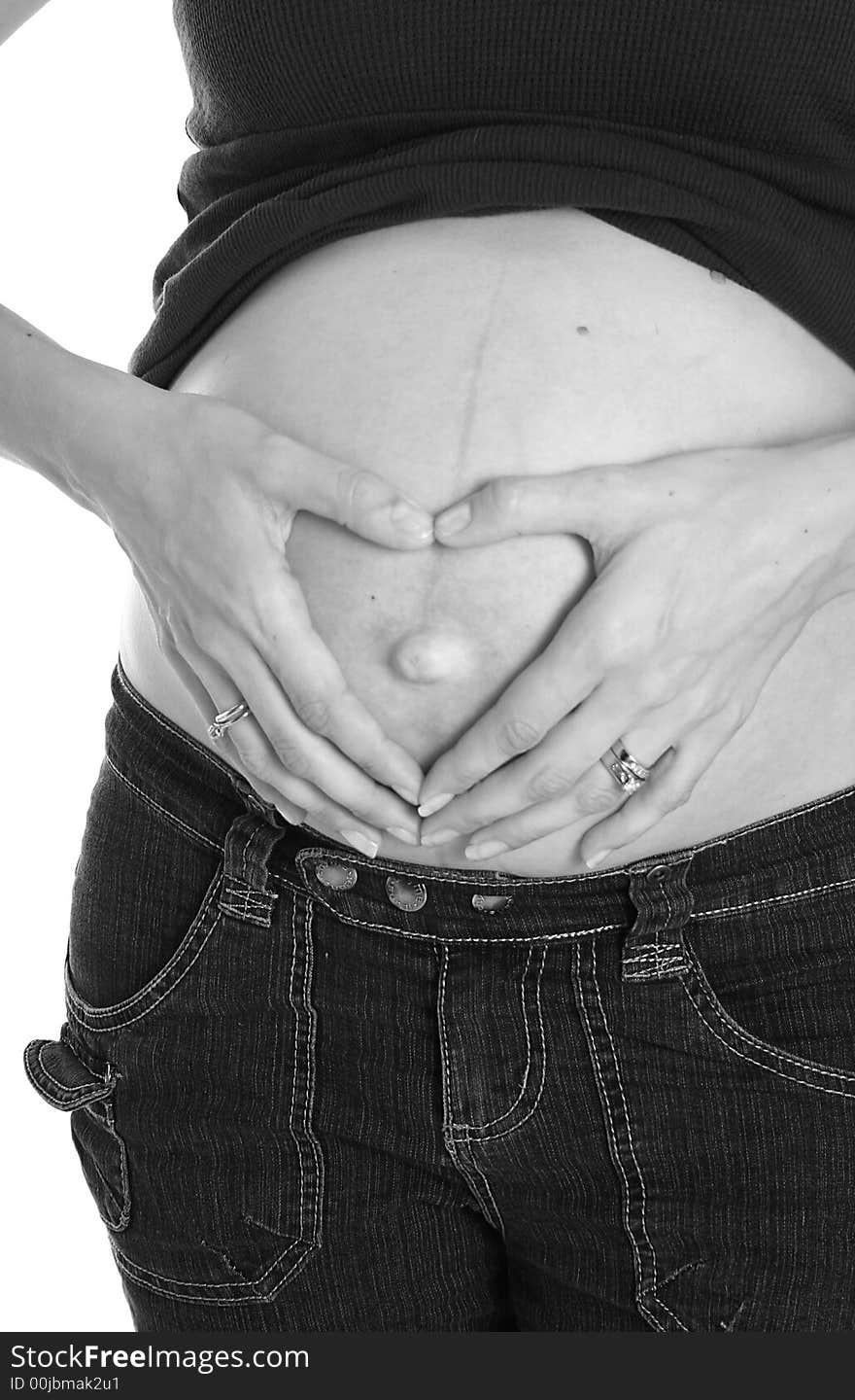 Woman hands shaped like a heart on her pregnant belly. Woman hands shaped like a heart on her pregnant belly.